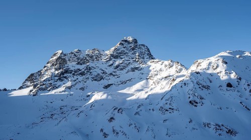 Mountain peak Piz Kesch with snow, view at the Kesch hut in winter, Grisons Haute Route, Albula