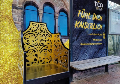 Bus stop in the old town centre with golden Kaiserstuhl and the words Fühl Dich Kaiserlich, Goslar,