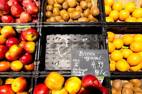 Fruit counter in a supermarket or organic food shop, here with different types of apples, kiwis,