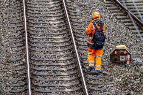 Worker on the railway tracks, after the end of his shift, walking home from the tracks, North