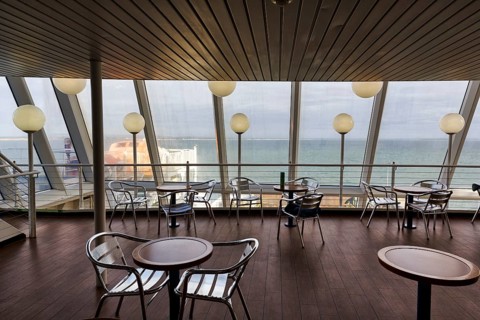 Empty tables and chairs, deck of a ferry to Wales with a view of the sea, interior shot, Rosslare,