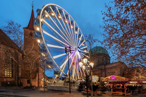Ferris wheel at the winter village, Christmas market at dusk, St James' Church on the left, St