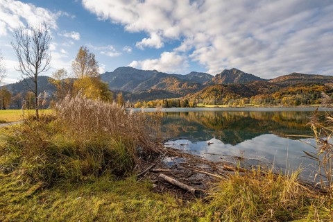 On the shore of Lake Lake Kochel with reflection, autumn landscape with mountain peaks Herzogstand