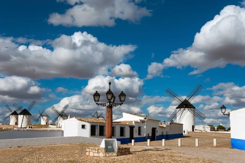 Windmills and street lamp in a charming village under a blue sky with clouds, windmills and
