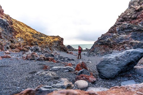 A tourist man on Djupalonssandur beach on the Snaefellsnes peninsula in winter in Iceland