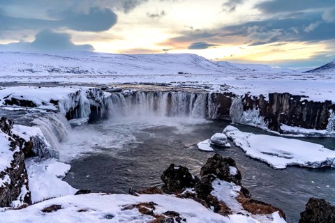 Beautiful landscape at frozen Godafoss waterfall at sunset in winter, Iceland, Europe