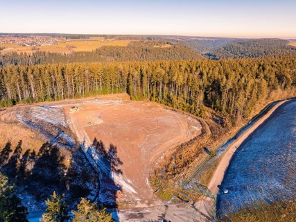 View of deforested land and neighbouring forests under a clear sky, landfill. Neubulach, Black