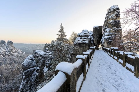 Snow on the Bastei bridge, rock gate and rock castle Neurathen in the morning, Saxon Switzerland,