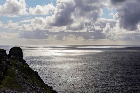 Rocky coast with a view of the sea under dramatic clouds, Cliffs of Moher