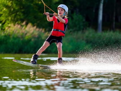 Boy or girl with wakeboard in the lake, water sports, water skiing in the wake park
