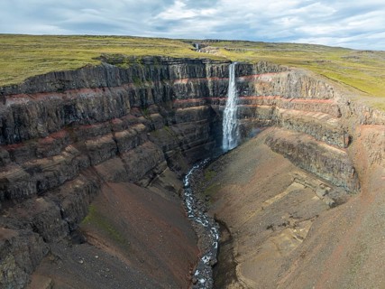 Waterfall Hengifoss, basaltic layers interwoven with red sedimentary layers, aerial view, Iceland,