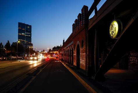 Cyclists and cars to the sunrise at the Oberbaum Bridge and the Amazon office tower Edge East Side,