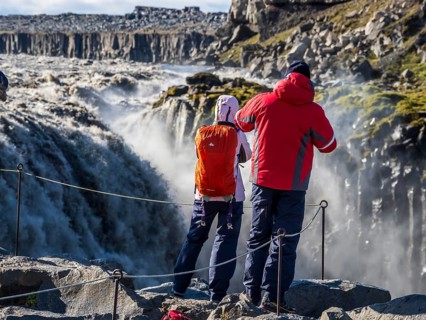Tourist at viewpoint close to waterfall Dettifoss, east side, Iceland, Europe