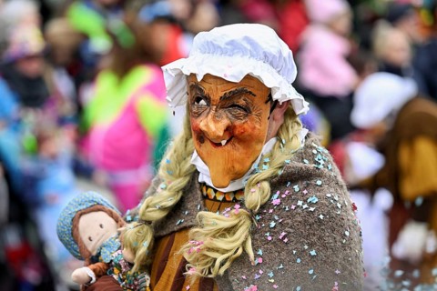 Person masked as a grandmother at the carnival parade of the Wey guild on Rose Monday, Güdismäntig,