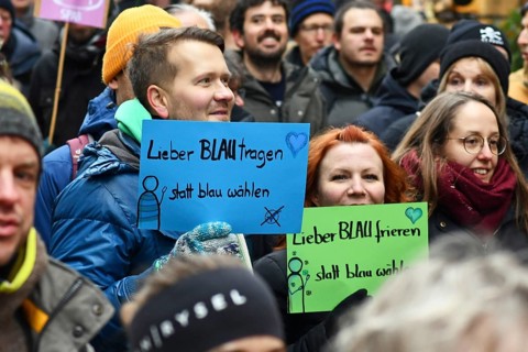 Heidelberg, Germany - February 12th 2025: Person holding up sign saying 'I'd rather wear blue than