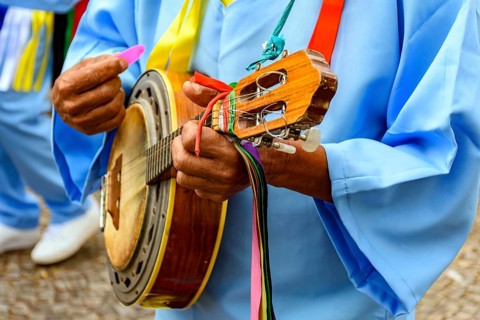 Hands of banjoist on the streets of Brazil wearing colorful clothes during a traditional religious