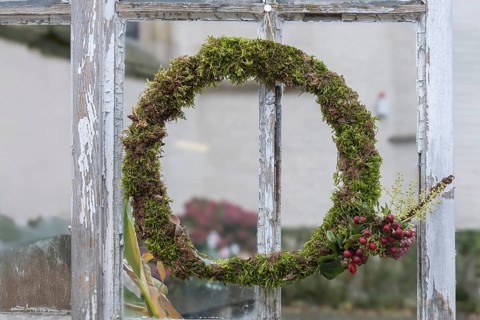 Door or window wreath made of natural materials in front of an old window, decoration, North
