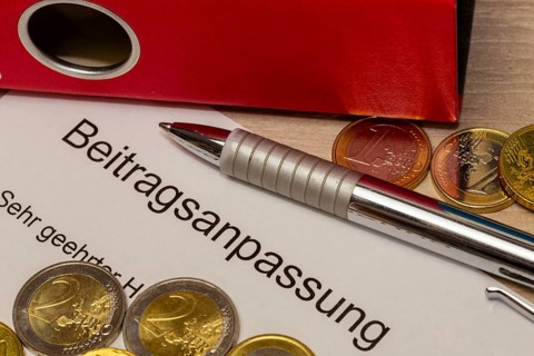 Symbolic image of contribution increase: cover letter, euro coins, biros and folder