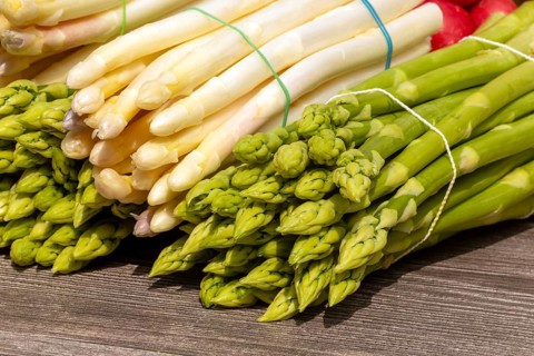 Green asparagus and white asparagus decorated on a rustic wooden table