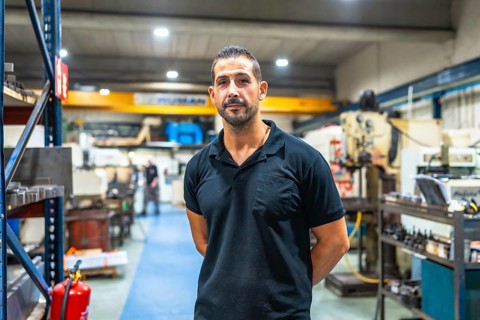 Portrait of a caucasian adult manual worker standing with hands on back looking proud in the
