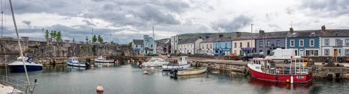 Small harbour with boats and surrounding buildings under a grey sky, Ballycastle