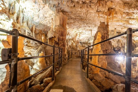 Tourists enjoy a train ride through the illuminated walkways of postojna cave, marveling at the