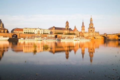 Silhouette of the Old Town with reflection in the Elbe in the morning, steamboats on the