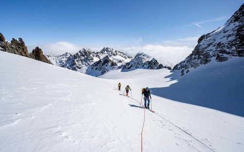 Ski tourer with rope, rope team on the Vadret da Porchabella glacier on the ascent to the summit of