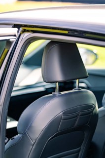 Detailed view of the rear vehicle interior with a leather seat and headrest, e-car sharing, Deer
