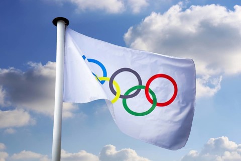 Olympic flag in front of a blue sky