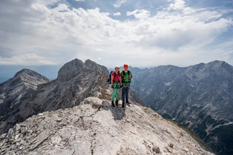 Couple, two mountaineers with helmets on a narrow rocky ridge, crossing the Jubiläumsgrat, view of