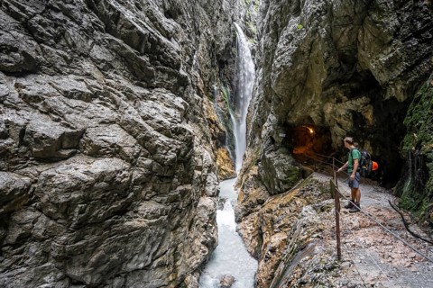 Waterfall and mountain stream Hammersbach in a canyon, mountaineers on a hiking trail in a gorge,