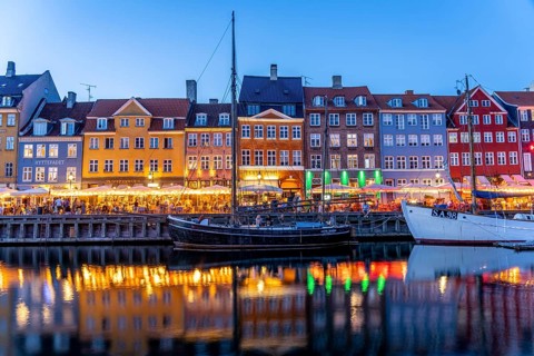 Colourful houses, restaurants and historic ships on the Nyhavn canal and harbour at dusk,
