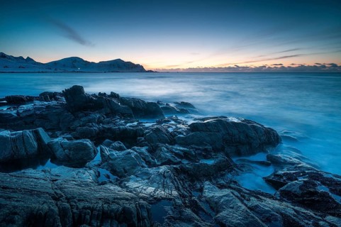 Long exposure after sunset, winter at Skagsanden, rocks washed over by the sea on the beach at