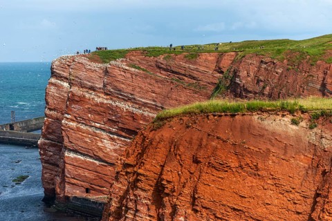 Red coloured sandstone, steep cliff coast of the high seas island of Heligoland, home of the