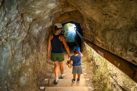 Mother and son walking through a tunnel in tolmin gorge, a popular tourist destination in slovenia