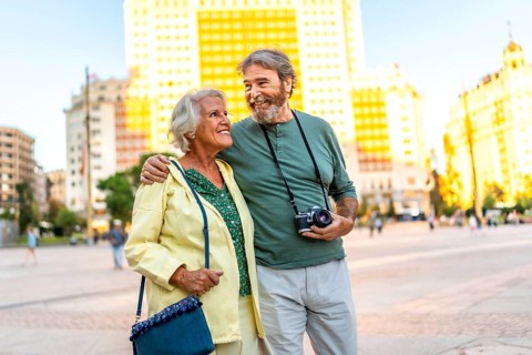 Senior modern couple walking in urban square visiting the city together