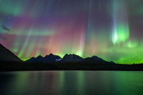 Northern lights over Bergen in the Lyngen Alps, reflection on the lake, Troms og Finnmark, Norway,