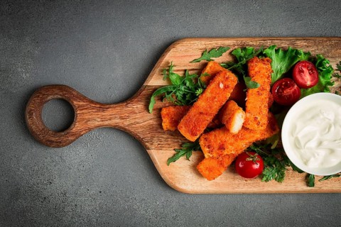 Fried fish nuggets, with white sauce, arugula and cherry, no people