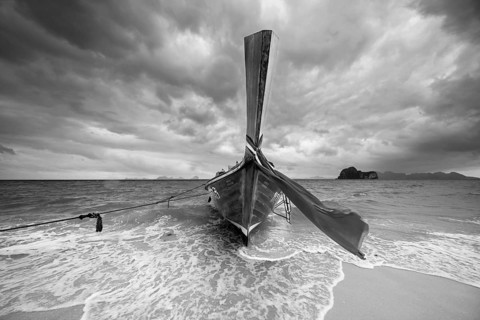 Longtail boat on the beach, dark rain clouds behind, Koh Ngai Island, Andaman Sea, Satun Province,