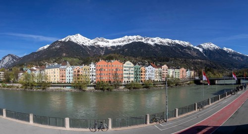 Colourful buildings along the Inn river with snow-covered Nordkette in the background, Karwendel