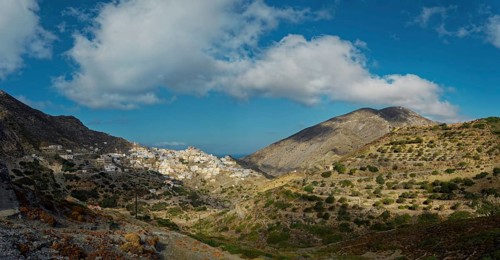 A vast landscape with mountains and the picturesque village of Olymbos in the valley under a clear