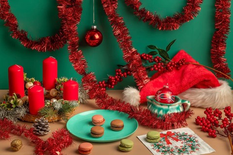 Christmas scene with red candles on an Advent wreath, garlands and macaroons on a table