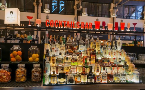 Eine gut bestückte Cocktailbar mit Flaschen verschiedener Spirituosen und bunter Beleuchtung in