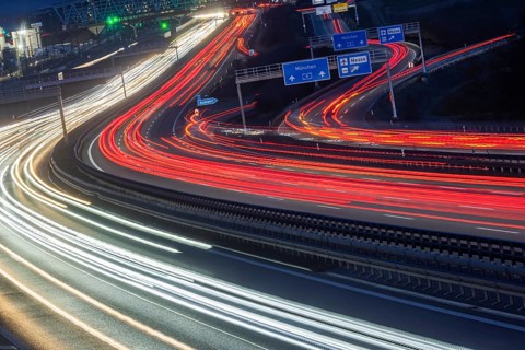 A8 motorway at Stuttgart Airport in the evening. Heavy traffic, lanes of light. Modern architecture