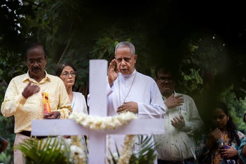 People from Christian community light candles and offer prayers on the grave of their relative