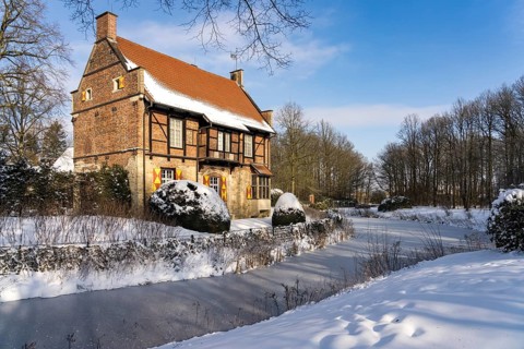 The snow-covered moated castle Haus Bisping in winter, Drensteinfurt, Münsterland, North