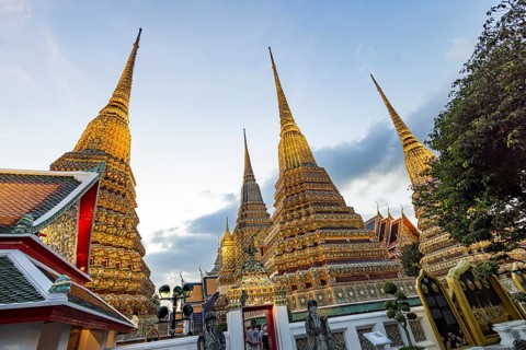 Wat Pho temple at sunset. Bangkok's oldest Buddhist monastery near the Grand Palace. Four chedis