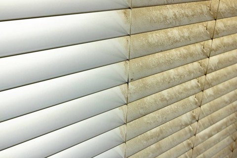 Residential window shades showing the before and after of a good cleaning, one side clean and one