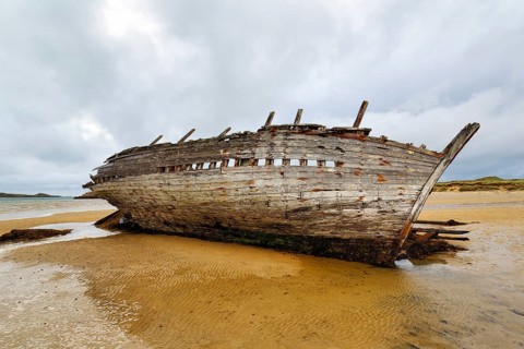 Wooden shipwreck Eddie's Boat on sandy beach, low tide, sandbank, Bunbeg, Magheraclogher beach,